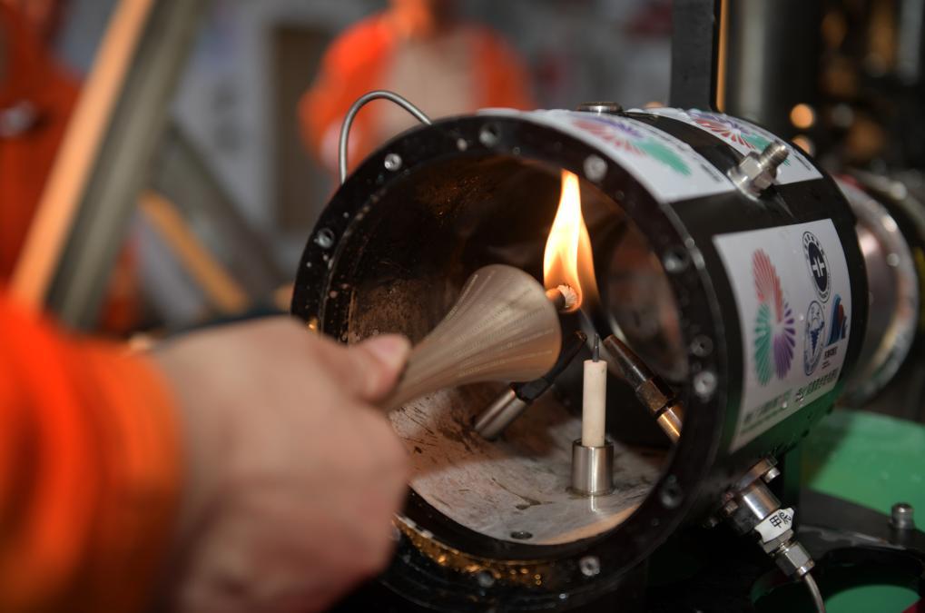 9月18日，在科考船甲板面，工作人员从搭载在“海马”号深海遥控潜水器上的采火装置里取火。