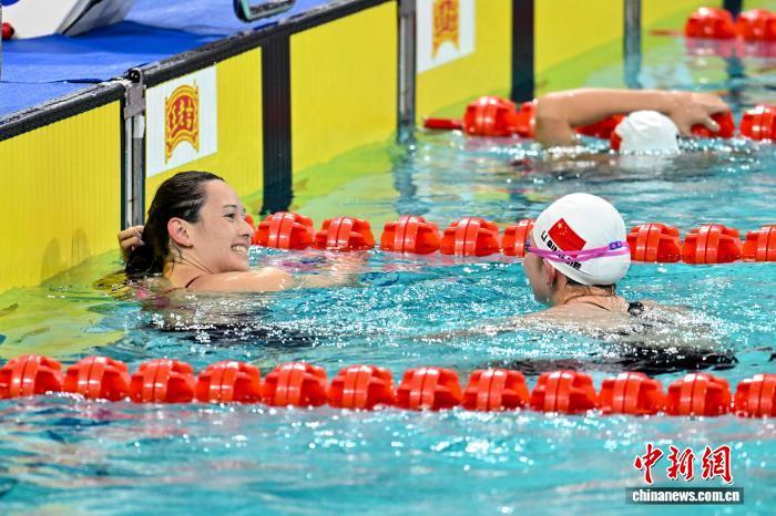 11月13日晚,第十五届全国运动会女子200米自由泳决赛在深圳大运中心游泳馆开赛,香港选手何诗蓓夺得冠军。图为何诗蓓(左)与李冰洁交流。中新社记者韦亮摄