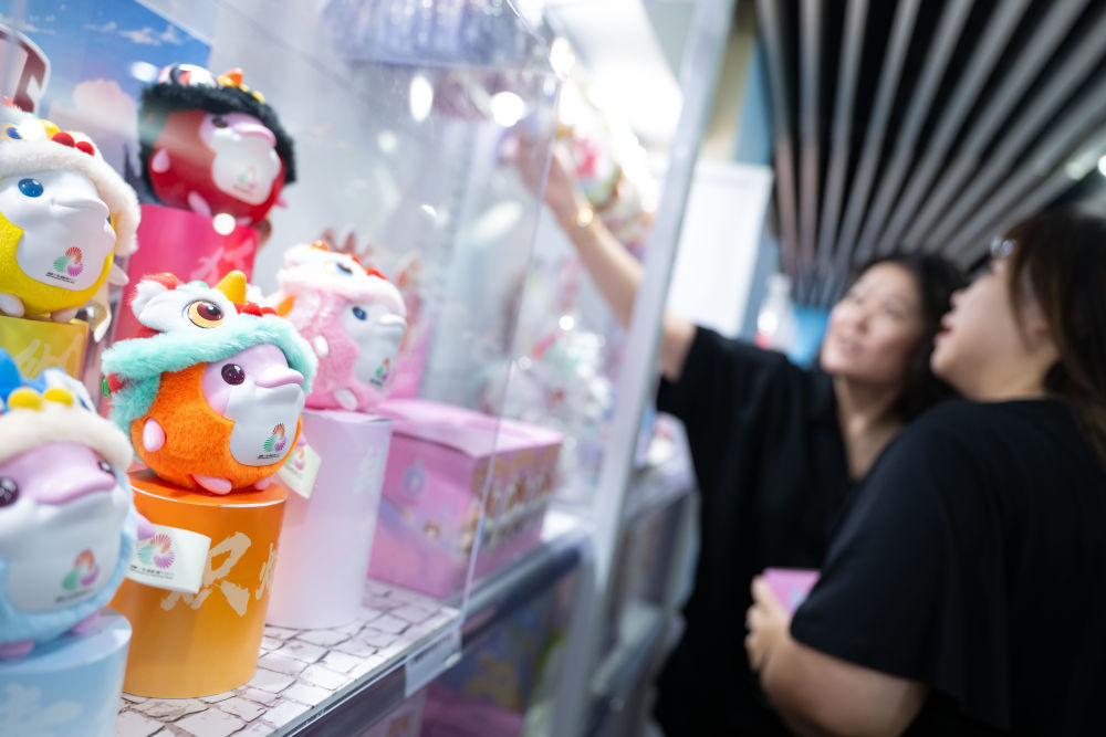 ↑8月1日,市民在十五运会和残特奥会澳门赛区官方特许商品零售店选购。新华社发(张金加摄)