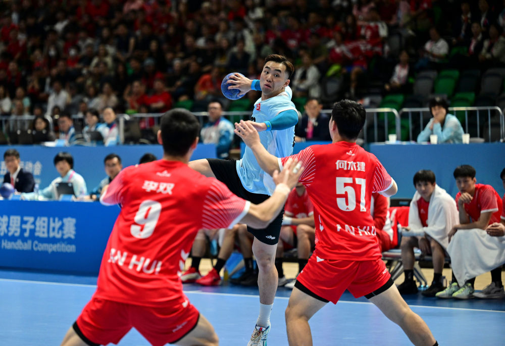 ↑11月8日,在香港进行的第十五届全国运动会男子手球半决赛中,香港队球员连润滔(中)在比赛中射门。新华社记者 于洋 摄