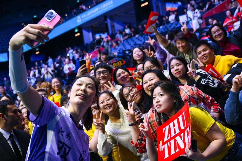 11月18日，河南队球员朱婷（前）在排球女子成年组5-8名半决赛后与球迷合影。