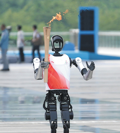 人形机器人“夸父”在传递火炬。