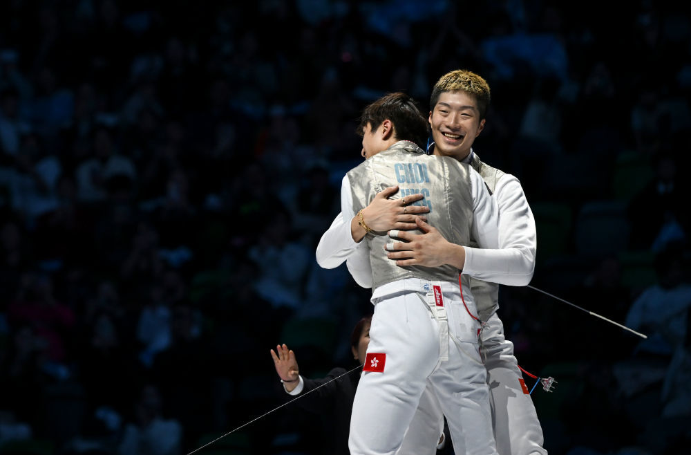 11月19日，香港队选手蔡俊彦（左）和队友张家朗在比赛后相拥庆祝夺冠。新华社记者 胡虎虎 摄