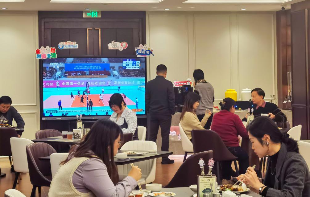 11月20日，游客在广州一家餐厅内用餐，一旁的电视正转播全运会比赛。新华社记者洪泽华 摄