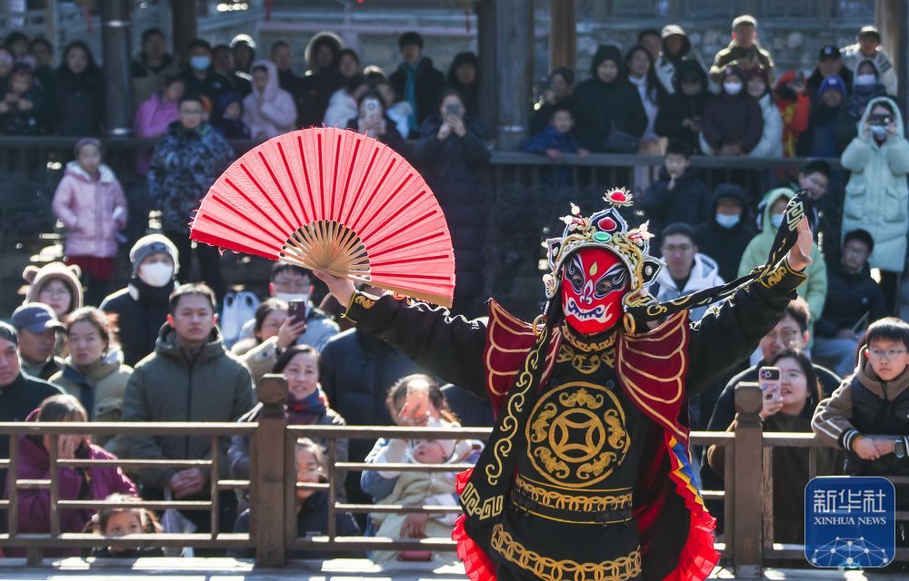 ↑ 1月2日，人们在江苏省句容市宝华山国家森林公园观看川剧变脸表演。新华社发（钟学满摄）