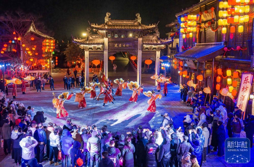 ↑ 1月1日，游客在江苏省盐城市大纵湖旅游度假区的东晋水城观看非遗节目表演（无人机照片）。新华社发（周社根摄）