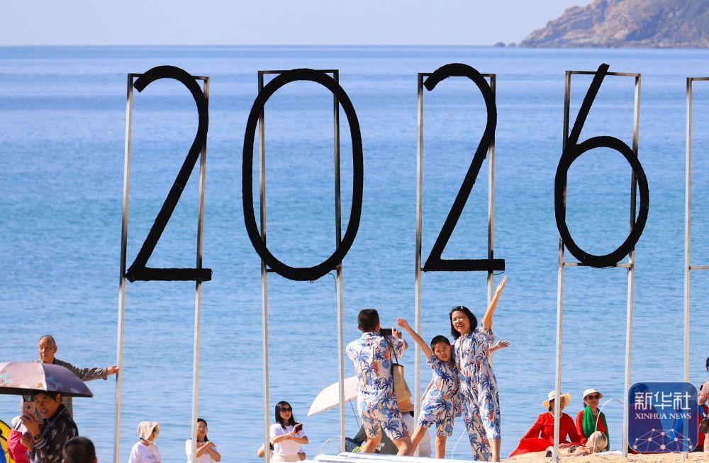 ↑ 1月1日，游客在海南省三亚市大东海旅游区拍照。新华社发（李学仕 摄）