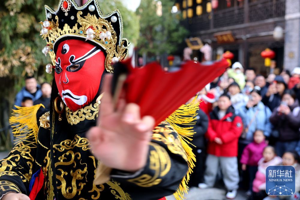 ↑ 1月1日，在京杭大运河畔的山东省枣庄市台儿庄古城，民间艺人在进行“变脸”表演。新华社发（孙中喆 摄）