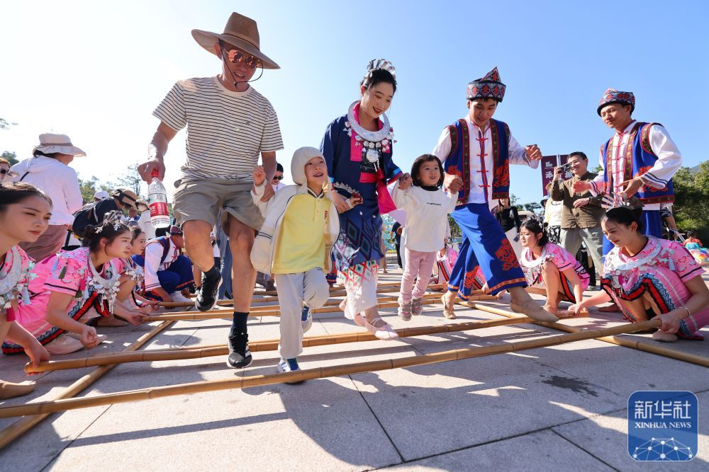↑ 1月1日，游客在海南省三亚南山文化旅游区跳竹竿舞。新华社发（陈文武 摄）