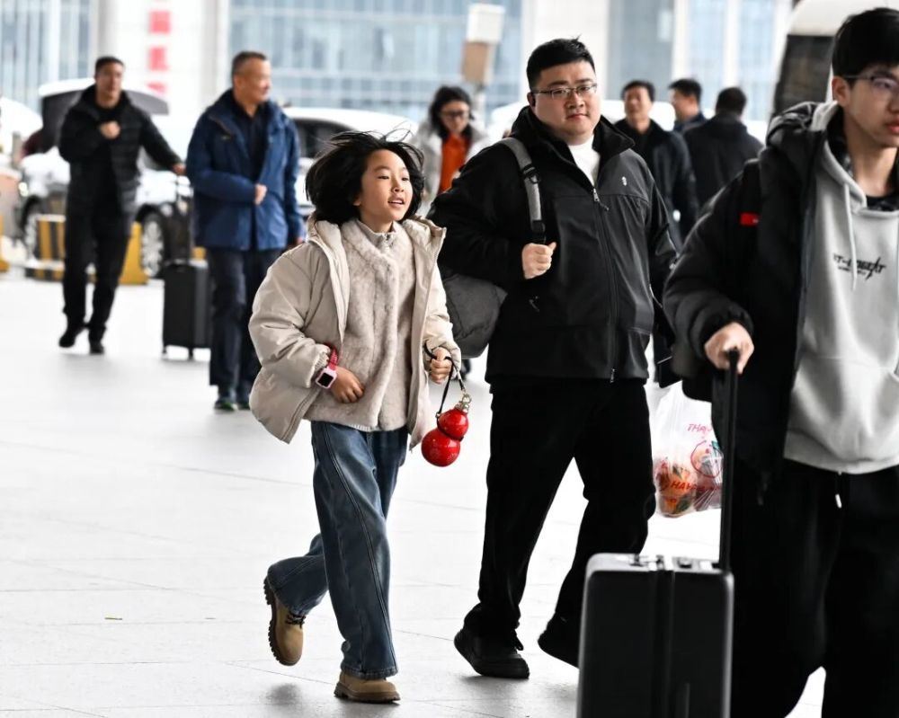 2月6日，在南京南站，小朋友跟随家人准备进站乘车。新华社记者 季春鹏 摄