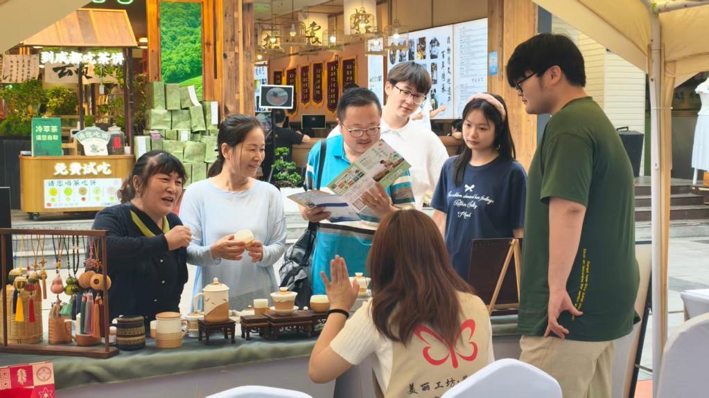 5月17日，四川成都市民游客在幸福集市选购残疾人制作的文创商品。（成都市残联供图）