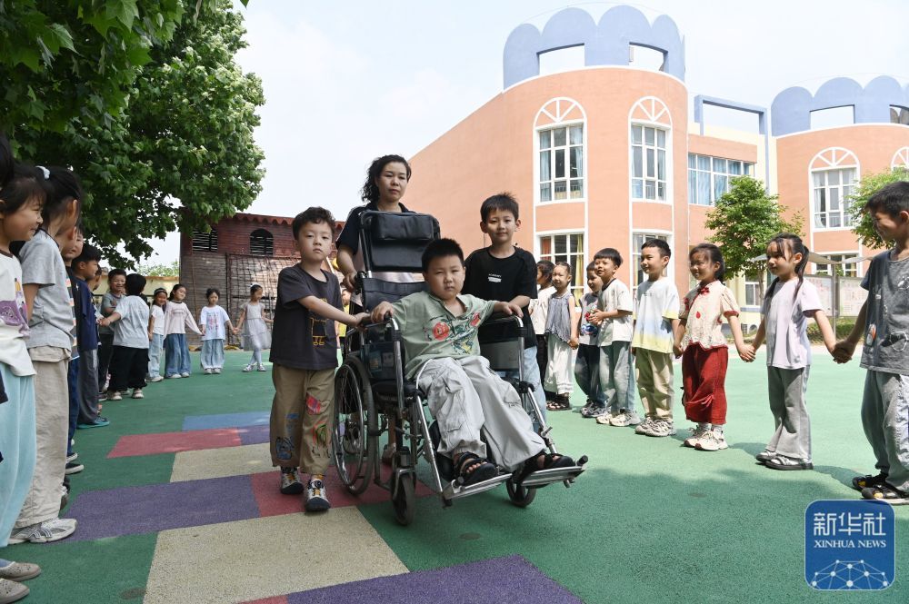↑ 5月15日，河南省沁阳市第一幼儿教育集团白庄村幼儿园的小朋友进行关爱残障互动体验。新华社发（杨帆摄）
