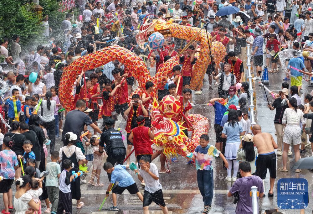 ↑ 6月20日，人们在贵州省黔东南苗族侗族自治州施秉县城参加“泼水龙”活动（无人机照片）。新华社发（磨桂宾摄）