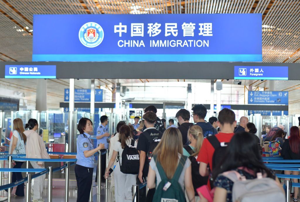 7月5日,北京边检总站的移民管理警察在首都国际机场3号航站楼入境现场引导旅客通关。(受访者供图)