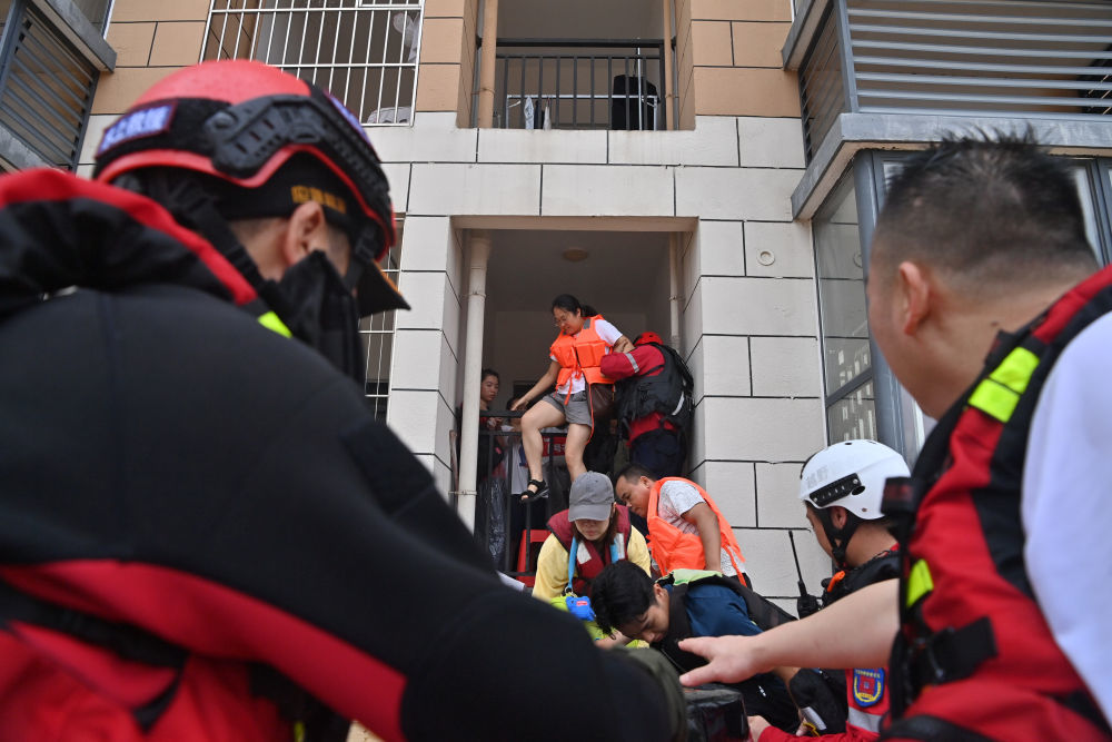 ↑ 7月8日，救援人员在广西贵港市西江教育园区转移被困教师。