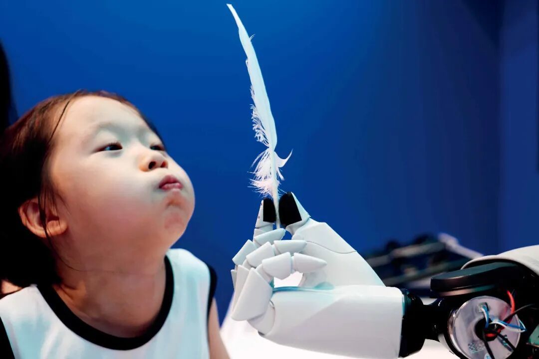 8月21日，2026世界机器人大会期间，小观众感受灵巧手的超轻微风力精细感知。摄影/本刊记者 王紫儒