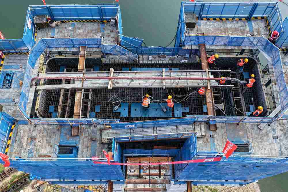 8月21日，中铁十一局承建的G331国道拉古哨至浑江口段大久才江口特大桥主塔全部封顶，这是工人在进行混凝土浇筑作业（无人机照片）。新华社发（中铁十一局供图）