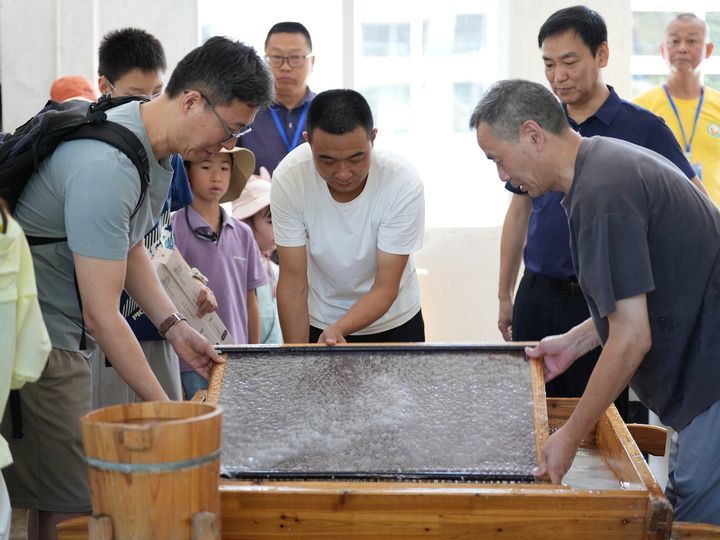 7月31日，游客在泾县中国宣纸小镇内体验宣纸制作。新华社发