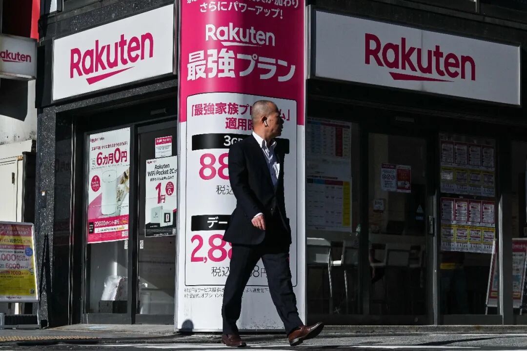 2024年5月14日，在东京街头，一名男子走过日本乐天集团的一家店铺。新华社/法新社