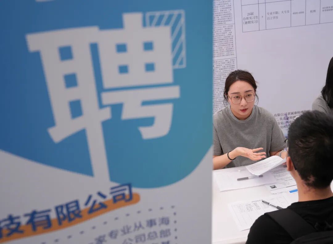 2025年5月13日，一家上市公司的招聘代表（左）在2025杭州市大学生就业&middot;见习招聘会上与前来求职的青年学生交流 / 新华社记者韩传号 摄