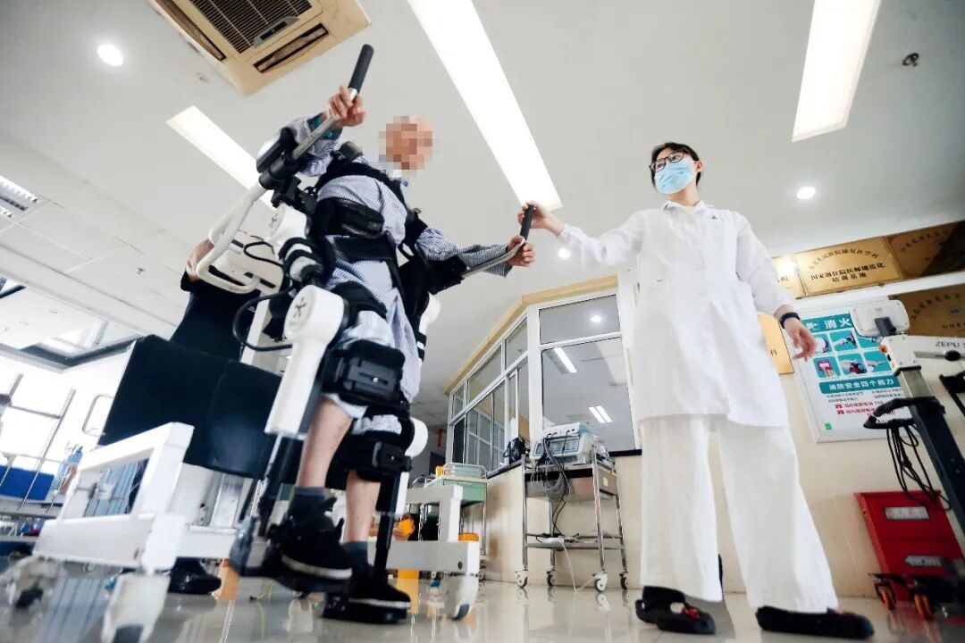 2025年8月，江苏省扬州市第二人民医院的医护人员在帮一名患者利用外骨骼机器人进行康复训练。图/视觉中国